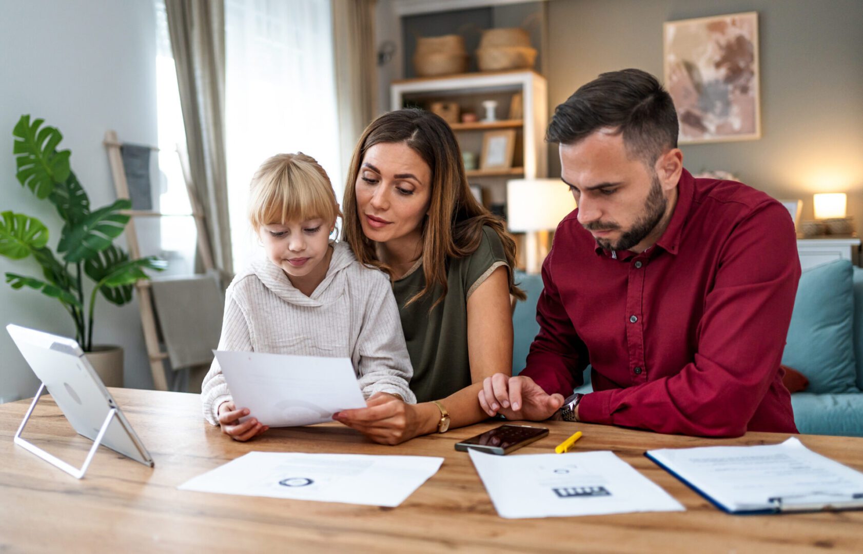 Young family with daughter managing a budget and paying bills and taxes